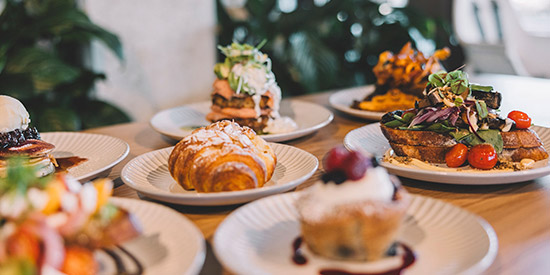 An delicious assortment of breakfast items from a local Maroochydore cafe, including croissants, muffins and pancakes.